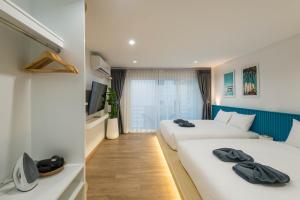 a hotel room with two beds and a tv at Otter House Aonang Soi 13 in Ao Nang Beach