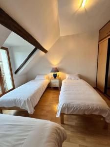 a bedroom with two beds and a table with a lamp at Happy House - 1h30 de Paris in Batilly-en-Gâtinais