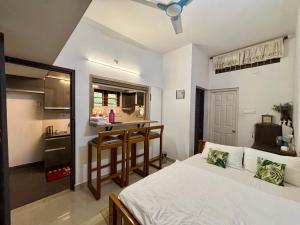 a bedroom with a bed and a small kitchen at Gloria Homestay ,Thrissur in Trichūr