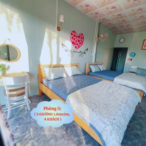 een slaapkamer met 2 bedden en een stoel bij Homestay Nguyễn Hưng in Tân Tạo