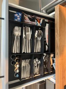 a drawer filled with utensils in a kitchen at Stilvolles Design Apartment mit Rheinblick inkl Netflix & Parkplatz in Düsseldorf