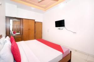 a bedroom with a bed with a tv on the wall at Hotel Queensland in Amritsar
