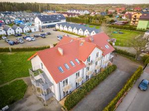 an aerial view of a building with an orange roof at Apartament Tropikalny by Holiday&Sun in Grzybowo