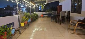 eine Terrasse mit Pflanzen, einem Tisch und Stühlen in der Unterkunft Bonjour Travellers Hostel in Hyderabad