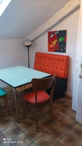 una mesa y una silla con un banco en una habitación en DÉDÉ DU VAL B&B, en Florac