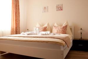 Schlafzimmer mit einem Bett mit rosa und weißen Kissen in der Unterkunft Apartmany Fonte in Orechová Potôň