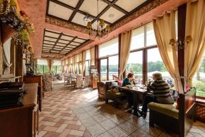 zwei Personen sitzen an einem Tisch in einem Restaurant in der Unterkunft Vila Arnika in Druskininkai
