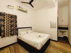 Dreamy Residency في بونديتْشيري: غرفة نوم مع سرير ومروحة سقف
