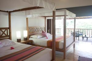 1 dormitorio con 2 camas y balcón en Ratnakara, en Dondra East