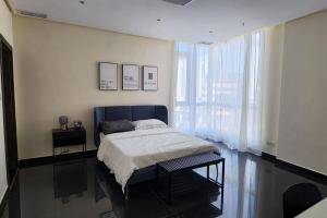 a bedroom with a bed and a large window at Smart Stay Salmiya apartment in Kuwait