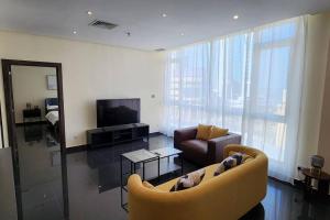 ein Wohnzimmer mit einem Sofa und einem TV in der Unterkunft Smart Stay Salmiya apartment in Kuwait