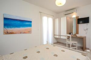 a bedroom with a bed and a desk and a painting at Irini Studios in Agia Anna Naxos