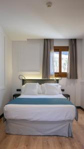 ein großes Bett in einem Zimmer mit Fenster in der Unterkunft Hotel Boutique Puerta de las Granadas in Granada