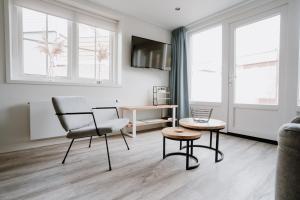 ein Wohnzimmer mit einem Stuhl und einem Tisch in der Unterkunft Ons Kotje in Aagtekerke