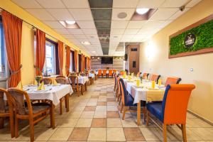 a restaurant with tables and chairs in a room at Penzión Esprit in Sučany