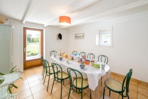 comedor con mesa blanca y sillas en La Maison des Vacances - Maison avec grand jardin, en Lantic