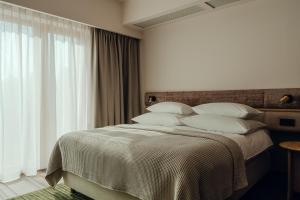 um quarto com uma cama grande e almofadas brancas em PURO Hotel Poznań Stare Miasto em Poznań