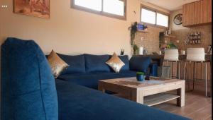 een woonkamer met een blauwe bank en een tafel bij Lake House Boulaouane in El Jadida