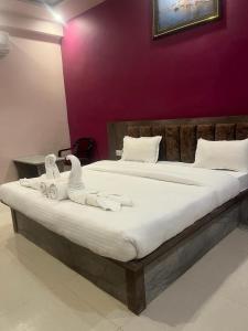 1 dormitorio con 1 cama grande y toallas. en Kashi Inn, en Varanasi