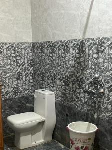 baño con aseo y papel pintado en blanco y negro en Kashi Inn, en Varanasi