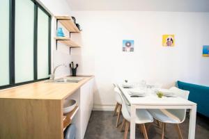 cocina con fregadero, mesa blanca y sillas en Studio - centre historique, en Agde