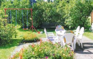 een tuin met een tafel en stoelen en een schommel bij Amazing Apartment In Neuhermsdorf With Wifi in Neuhermsdorf