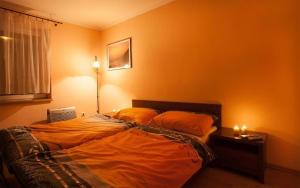 ein Schlafzimmer mit einem Bett mit zwei orangefarbenen Kissen in der Unterkunft Relax Vila se zahradním wellness in Ostrava