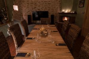 a long table in a room with chairs and a fireplace at Relax Vila se zahradním wellness in Ostrava
