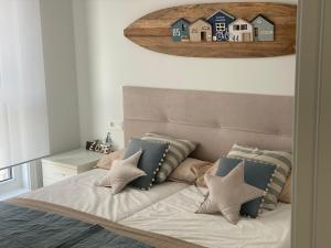 a bedroom with a bed with pillows and a picture of houses at Salberdin 6 Apartamento en nueva zona residencial en Zarautz by Egona in Zarautz