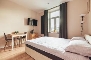 a bedroom with a bed and a desk and a window at Przytulny apartament przy dworcu in Radom