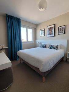 キブロンにあるオテル ポール アリゲンのベッドルーム1室(青いカーテン付きの大型ベッド1台付)