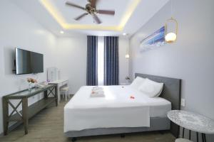 a bedroom with a bed and a desk and a television at Bella Sunset Town Hotel - Phu Quoc in Phú Quốc +71 photos