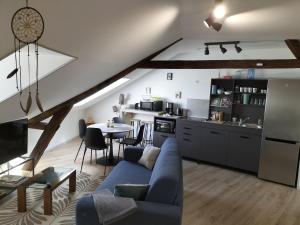 a living room with a blue couch and a kitchen at Brume de Loire in Bourgueil