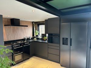 a kitchen with black and stainless steel appliances at The Old Telephone Exchange in Huddersfield