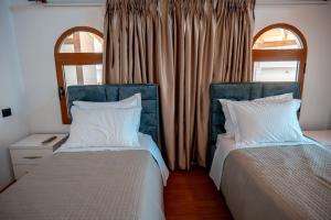 two beds sitting next to each other in a bedroom at Fabio Guest House in Gjirokastër
