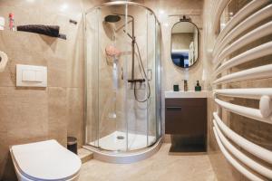 a bathroom with a shower and a toilet and a sink at Przytulny apartament przy dworcu in Radom