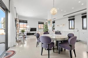 Modern 2BR Private House Neve Tsedek by HolyGuest في تل أبيب: مطبخ وغرفة طعام مع طاولة وكراسي