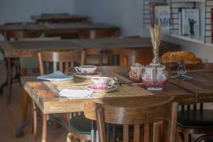 una mesa de madera con tazas y platillos. en chateau haut gouat, en Vertheuil-en-Médoc