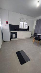 uma cozinha com um frigorífico, uma mesa e cadeiras em Lafleur_doré Studio em Le Vauclin