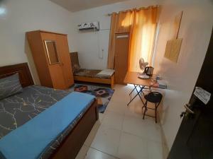 a small bedroom with a bed and a desk at Adbldna01 in Abu Dhabi