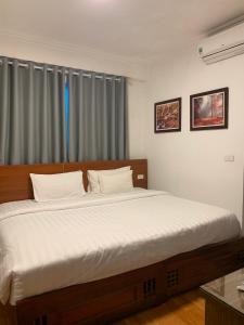 una camera da letto con un grande letto con lenzuola bianche di A25 Hotel - Đội Cấn 2 a Hanoi