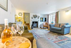 ein Wohnzimmer mit einem Sofa und einem Tisch mit Weingläsern in der Unterkunft Wherry Cottage, Sleeps 8 in Southwold