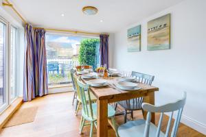 a dining room with a table and chairs and a window at Wherry Cottage, Sleeps 8 in Southwold