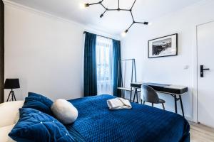 sypialnia z niebieskim łóżkiem i biurkiem w obiekcie Apartamenty Krupówki 48B w Zakopanem