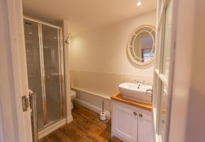 a bathroom with a sink and a shower and a toilet at Wherry Cottage, Sleeps 8 in Southwold +15 photos