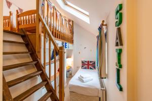 a small room with a bunk bed and stairs at Wherry Cottage, Sleeps 8 in Southwold