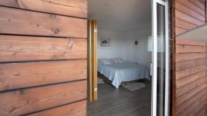 ein Schlafzimmer mit einem Bett und einer Holzwand in der Unterkunft MREŽNICA - ZELENA BAJKa in Generalski Stol