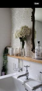 a bathroom with a sink and a vase of flowers at No 2 in Kirkby Lonsdale