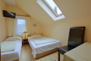 a small room with two beds and a window at Dom Polana Karpacz in Karpacz