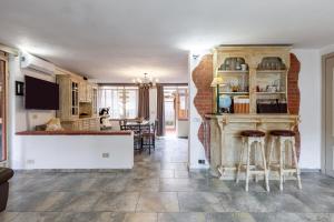 a kitchen and living room with a counter and stools at Loft in centro a Torre del Lago in Torre del Lago Puccini
